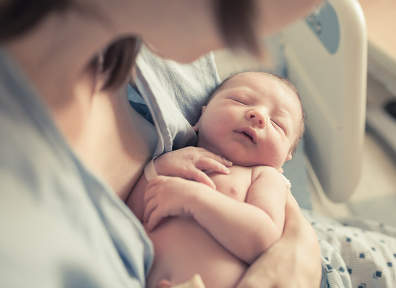 A baby sleeping on mother's chest