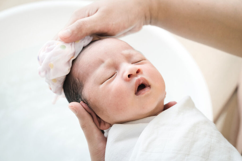 An adult washing the baby's hair